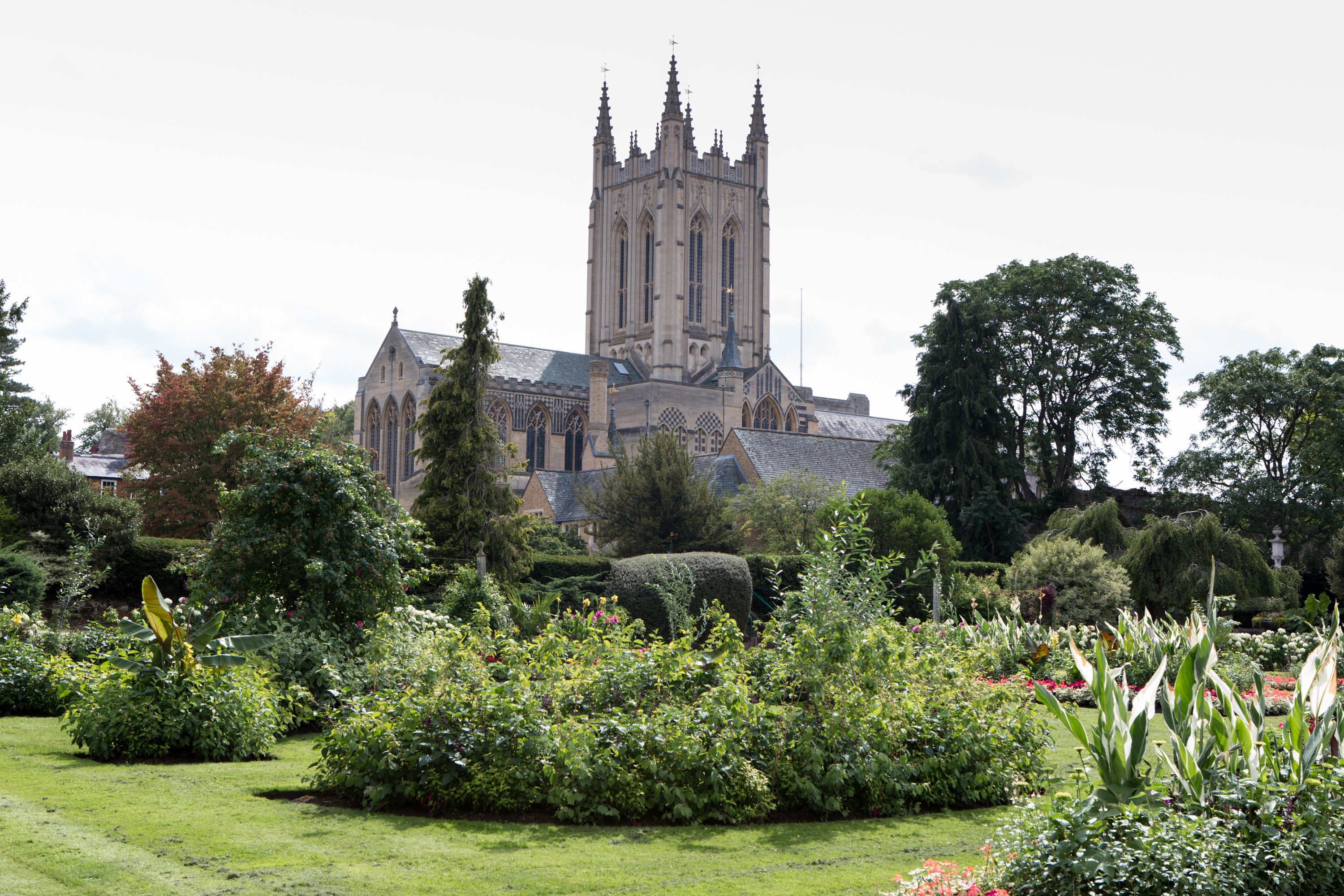 Bury St Edmunds cathedral on a cloudy day with Abbey Gardens in the foreground