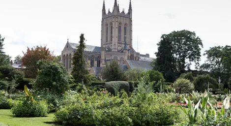 Bury St Edmunds cathedral on a cloudy day with Abbey Gardens in the foreground