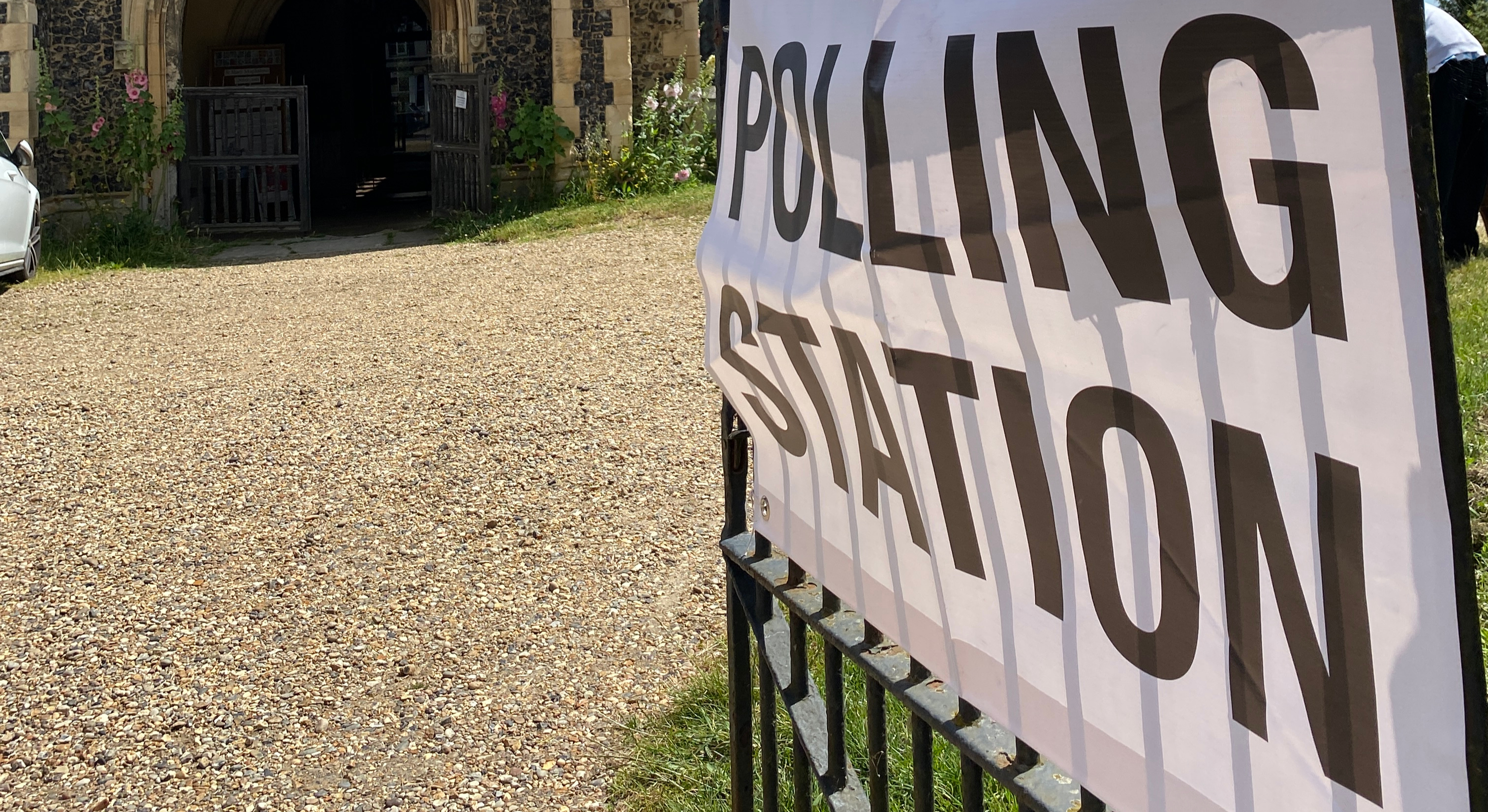 A polling station sign on a gate outside a church in Debenham, Suffolk